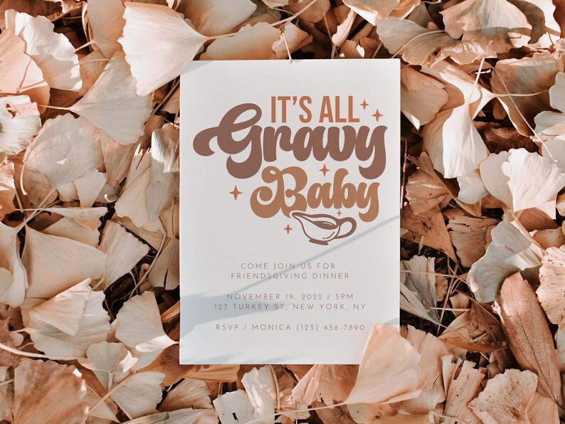 Op de afbeelding: Een witte uitnodigingskaart met bruine en oranje tekst die "It's All Gravy Baby" luidt. De kaart is versierd met kleine sterren en een sausbootpictogram. De tekst onder de titel luidt "Come join us for Friendsgiving Dinner, November 19, 2022 / 5PM, 123 Turkey St. New York, NY. RSVP / Monica (123) 456-7890."