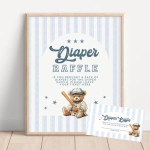 May include: A framed sign and matching card for a diaper raffle. The sign features a blue and white striped background, the words "Diaper Raffle", and a watercolor illustration of a teddy bear in a baseball uniform. The card has the same design.