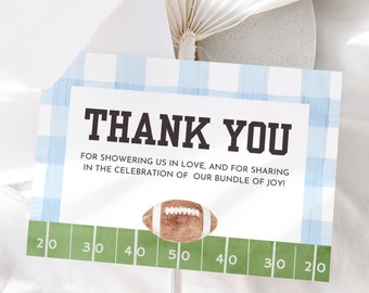 May include: A blue and white checkered thank you card with a football graphic and the text "THANK YOU" and "FOR SHOWERING US IN LOVE, AND FOR SHARING IN THE CELEBRATION OF OUR BUNDLE OF JOY!"  The card also has a green football field graphic with yard lines marked 20, 30, 40, 50, 40, 30, 20.
