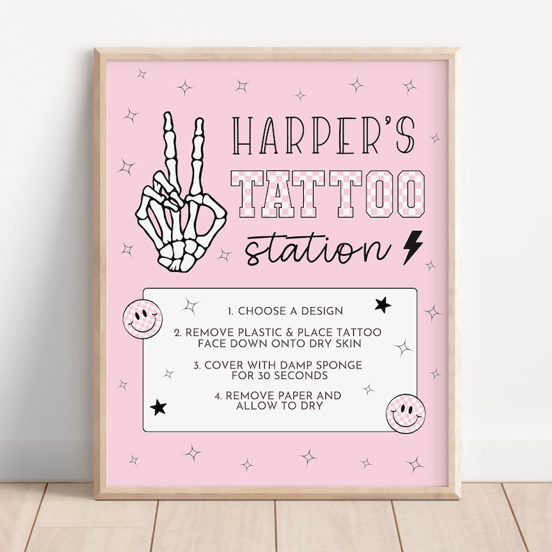 May include: A pink framed sign reading "Harper's Tattoo Station". The sign features a skeleton hand making a peace sign, stars, and instructions for applying temporary tattoos. The background is a light pink colour.