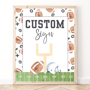 Pode incluir: Um sinal de futebol imprimível com fundo branco e um campo de futebol verde na parte inferior. O sinal diz "CUSTOM Sign" em texto preto e tem um capacete de futebol e uma bola de futebol no campo. O sinal é cercado por uma moldura marrom.
