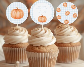 May include: Three cupcakes with white frosting and pumpkin-themed toppers. The toppers feature watercolor pumpkins on a blue and white checkered background. One topper says "Happy Birthday Lucas".