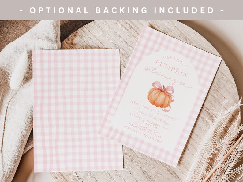 May include: Two pink gingham-patterned invitation cards with the text "Our Little Pumpkin is turning one" and a pumpkin illustration. The cards are on a wooden surface with decorative elements.
