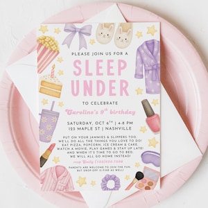 May include: A pink and white invitation for a sleepover party. The invitation includes illustrations of popcorn, cake, slippers, a robe, and makeup. The text reads "Sleep Under" and details the date, time, and location of the party.