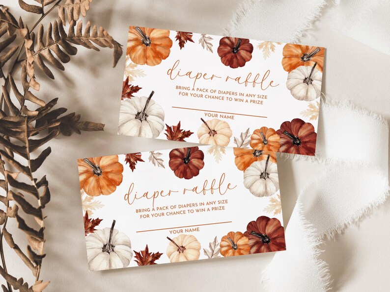 May include: Two diaper raffle cards with watercolor pumpkins in shades of orange, white, and burgundy, surrounded by fall leaves. The cards read "diaper raffle" and include space for a name.