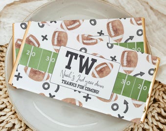 May include: A white chocolate bar wrapper with a football theme. The wrapper has a green and white football field design with the text "TWO Noah's 2nd year down THANKS FOR COMING!" printed on it.