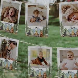 May include: A set of 6 printable photo cards with a woodland theme. Each card features a photo of a baby at different ages, from newborn to five years old. The cards are decorated with a campfire, tent, and bear.