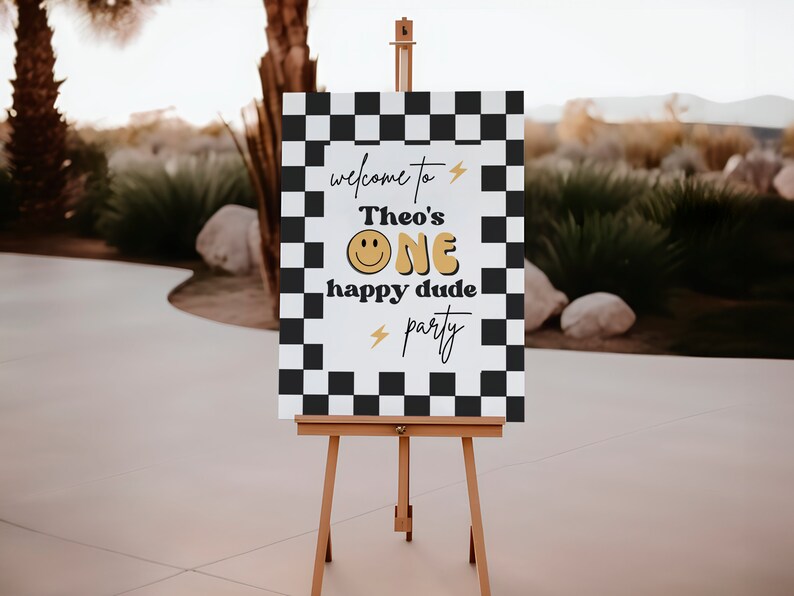 Puede incluir: Un cartel blanco con fondo de cuadros negros y blancos. El cartel dice "Bienvenido a la fiesta de Theo's One happy dude" con una carita sonriente amarilla y rayos.