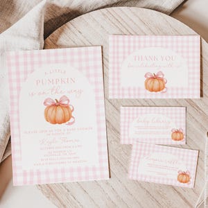 Puede incluir: Un conjunto de papelería para baby shower con un patrón de cuadros rosas. La invitación dice "A Little Pumpkin is on the Way" con una ilustración de calabaza. Las tarjetas adicionales incluyen "Thank You", "Baby Library" y "Diaper Raffle".