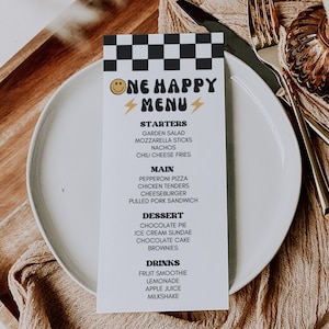 May include: A black and white checkered menu with the words "One Happy Menu" in a yellow and black retro font. The menu lists starters, main courses, desserts, and drinks. The menu is on a white plate with a brown napkin.