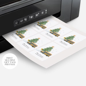 May include: Printable gift tags featuring a yellow school bus with a Christmas tree on top. The tags say "Thank you" and are printed on white paper. The tags are being printed on a black and white printer.