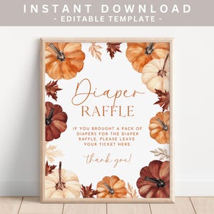 May include: A framed sign with a watercolor design for a diaper raffle. The sign features orange, white, and brown pumpkins and leaves around the border. Text on the sign reads "Diaper Raffle" and instructions for the raffle.