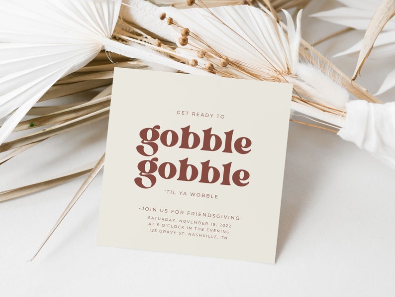 May include: A beige invitation card with brown text that reads "Get ready to gobble gobble 'til ya wobble." The invitation is for a Friendsgiving on Saturday, November 19, 2022, at 6 o'clock in the evening at 123 Gravy St. Nashville, TN.