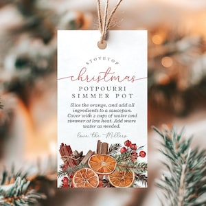 以下が含まれることがあります： 赤と黒で「Stovetop Christmas Potpourri Simmer Pot」という文字が書かれた白いタグ。タグには説明と、オレンジのスライス、シナモンスティック、ベリーの装飾的なイラストが含まれています。タグはひもで結ばれています。