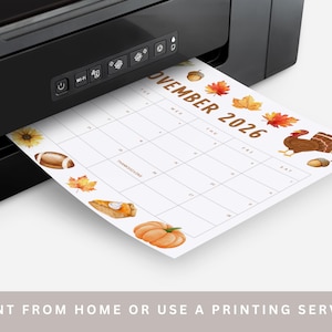 May include: A black printer printing a November 2026 calendar. The calendar features Thanksgiving-themed illustrations, including a turkey, pumpkin, and autumn leaves. The text at the bottom reads: -PRINT FROM HOME OR USE A PRINTING SERVICE-.