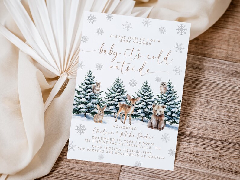 Puede incluir: Una invitaci&oacute;n de baby shower blanca con un tema de invierno. La invitaci&oacute;n presenta una escena de bosque nevado con animales, incluyendo un ciervo, un oso y una ardilla. El texto de la invitaci&oacute;n dice "baby it's cold outside" e incluye los nombres Chelsea y Mike Parker, la fecha y la hora de la ducha, y la direcci&oacute;n.