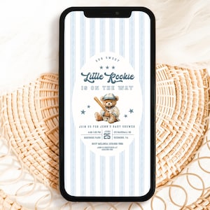 Puede incluir: Un teléfono inteligente muestra una invitación a un baby shower. El diseño presenta un oso de peluche con uniforme de béisbol, sosteniendo un bate, con el texto "Little Rookie is on the Way". El fondo tiene rayas azules y blancas.