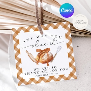 May include: A square gift tag with a brown and white gingham border. The tag features the text "ANY WAY YOU slice it WE ARE SO THANKFUL FOR YOU" with illustrations of a rolling pin, bread, and whisk. A brown string is attached.