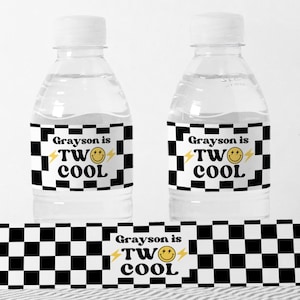 以下が含まれることがあります： 黒と白の市松模様のウォーターボトルラベル。ラベルには「Grayson is TWO COOL」の文字と、黄色のスマイリーと稲妻のグラフィックが描かれています。