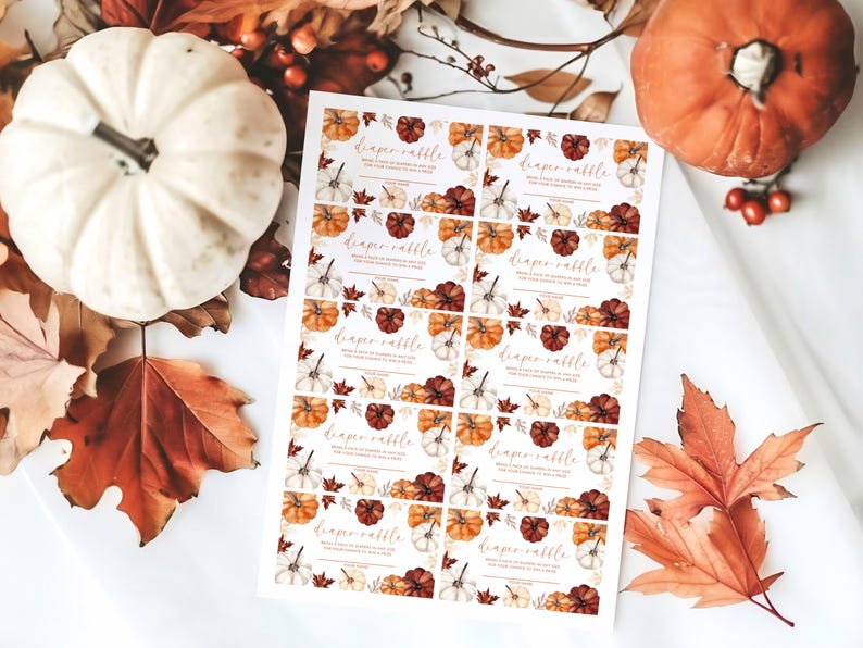 May include: A sheet of diaper raffle tickets with a fall theme. The tickets feature watercolor pumpkins in orange, white, and burgundy, with text that reads "diaper raffle". The scene includes pumpkins and fall leaves.
