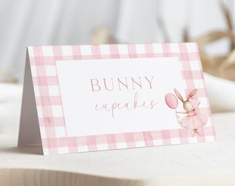 Puede incluir: Etiqueta de comida de vichy rosa y blanco con el texto "BUNNY cupcakes" y una ilustración de dibujos animados de un conejito con un tutú rosa y sosteniendo un globo rosa.
