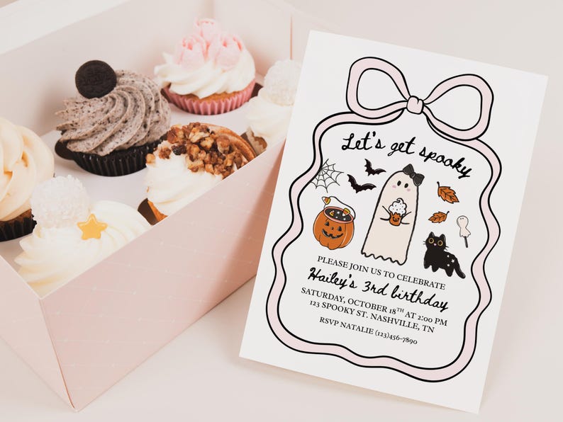 May include: A pink box of cupcakes and a Halloween-themed invitation. The invitation reads "Let's get spooky" and includes a ghost, pumpkin, and black cat illustration. Cupcakes have various toppings.