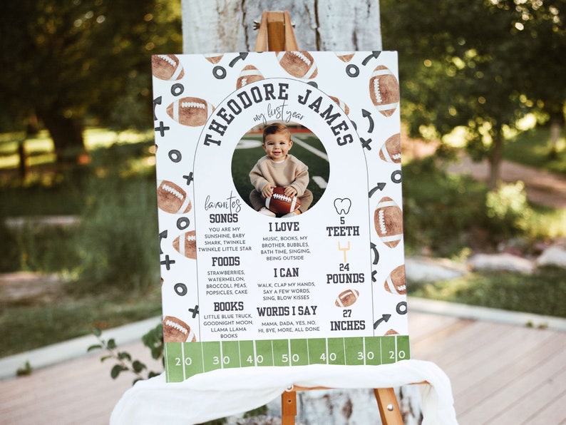 May include: A white and green football-themed first birthday milestone poster with a photo of a baby boy. The poster includes the baby's name, Theodore James, and details about his first year, including his favorite songs, foods, and books. The poster also includes his height, weight, and number of teeth.