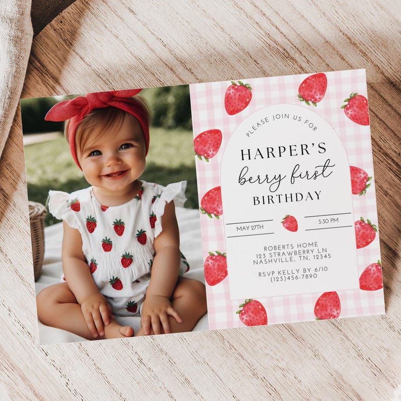 Może przedstawiać: Niemowlę w czerwonej opasce i białym body z czerwonymi wzorami truskawek. Obok dziecka zaproszenie urodzinowe z napisem "Harper's berry first birthday". Zaproszenie ma r&oacute;żowe tło w kratkę i ilustracje truskawek.
