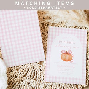 Puede incluir: Invitaci&oacute;n y papel a juego con estampado de cuadros rosas y blancos. La invitaci&oacute;n presenta una calabaza de acuarela con un lazo rosa y el texto "Our Little Pumpkin is turning one". La invitaci&oacute;n es para un primer cumplea&ntilde;os.