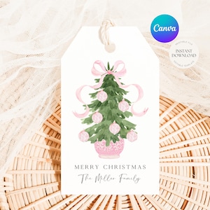Pode incluir: Uma etiqueta de presente branca com um desenho de árvore de Natal em aquarela. A árvore é verde com enfeites rosa e um laço rosa. A etiqueta diz "Merry Christmas" e "The Miller Family". Um logotipo Canva está no canto superior direito.
