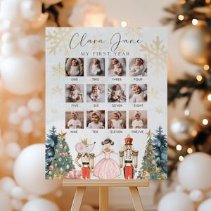 May include: A personalized baby's first year photo display. The poster features twelve small photos, one for each month, with the name "Clara Jane" at the top. Decorative elements include snowflakes, Christmas trees, and Nutcracker characters.