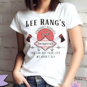 May include: White and silver unisex t-shirt featuring a red graphic of a fox with crossed axes and the text "Lee Rang's Honorably Acquired Antiquities You Can Bet Your Life We Aren't Sly".