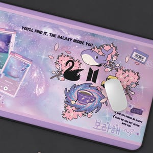 May include: A rectangular desk mat featuring a purple galaxy-themed background with various illustrations including a whale, a black swan, cherry blossoms, and music player interfaces. Text includes "YOU'LL FIND IT, THE GALAXY INSIDE YOU" and "CAUSE YOU'RE A BIG EXISTENCE, LET US SHINE!"