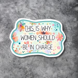 May include: A sticker with a white border and a light blue outline. The sticker has a floral design with the text "THIS IS WHY WOMEN SHOULD BE IN CHARGE" in black and white.