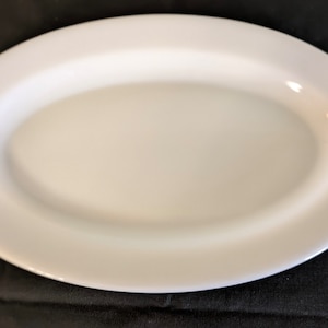 May include: White oval serving platter with a floral design in shades of pink, yellow, and green on each end.