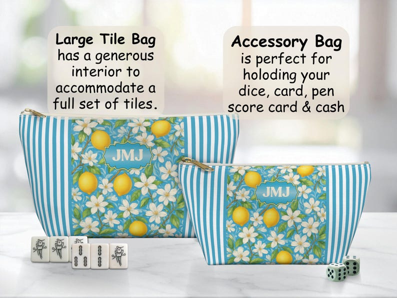 May include: Two zippered bags with a lemon and floral pattern. The bags have blue and white striped sides. The larger bag is labeled "Large Tile Bag" and the smaller bag is labeled "Accessory Bag". Mahjong tiles and dice are in front of the bags.