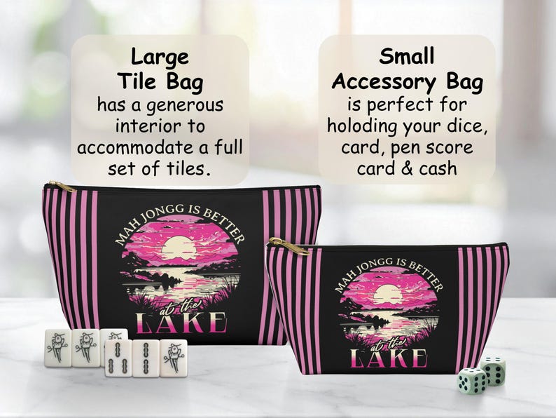 May include: Two zippered Mahjong tile bags, one large and one small, with a black background and pink vertical stripes. The bags feature a sunset lake scene and the text "Mah Jongg is Better at the Lake". Mahjong tiles and dice are also present.