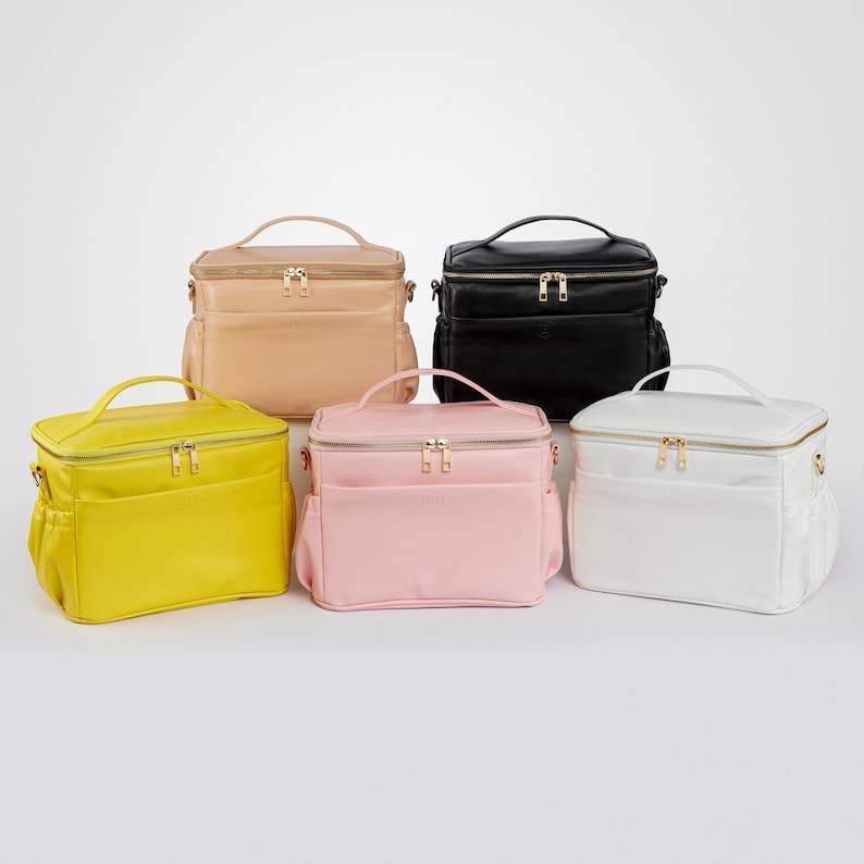 Peut inclure: Cinq sacs rectangulaires de diff&eacute;rentes couleurs : jaune, rose, beige, noir et blanc. Chaque sac est dot&eacute; d'une poign&eacute;e sup&eacute;rieure, de fermetures &eacute;clair dor&eacute;es, d'une poche avant et de poches lat&eacute;rales.