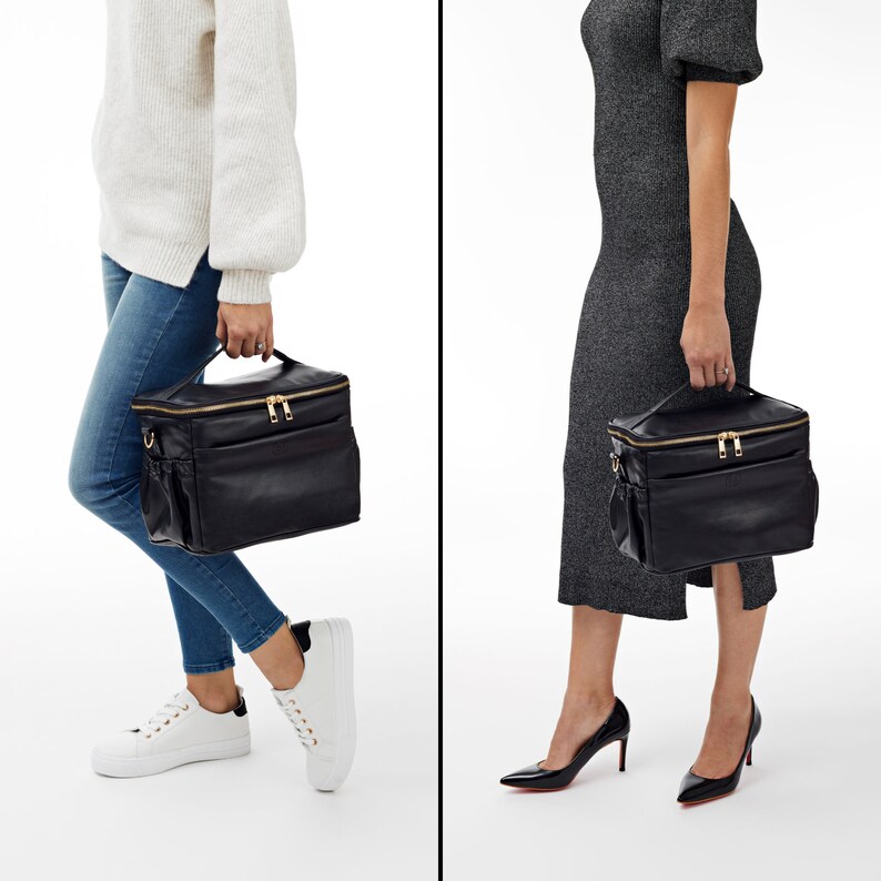 Peut inclure: Sac &agrave; main en cuir noir avec fermetures &eacute;clair et accessoires dor&eacute;s. Le sac a une poign&eacute;e sup&eacute;rieure et des poches lat&eacute;rales. Le sac est port&eacute; par une personne.