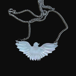 May include: A silver chain necklace with a white mother of pearl dove pendant.