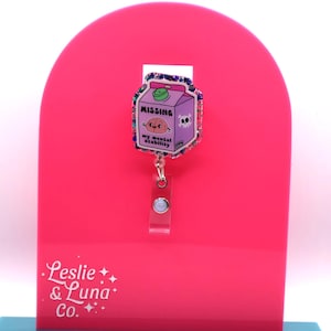May include: A pink and purple glitter badge reel with a cartoon milk carton that says "MISSING my mental stability".