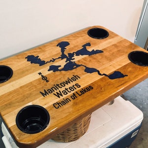 Puede incluir: Una mesa de madera con un mapa de la cadena de lagos de Manitowish Waters y cuatro portavasos. La mesa está hecha de madera de arce y tiene un acabado natural.