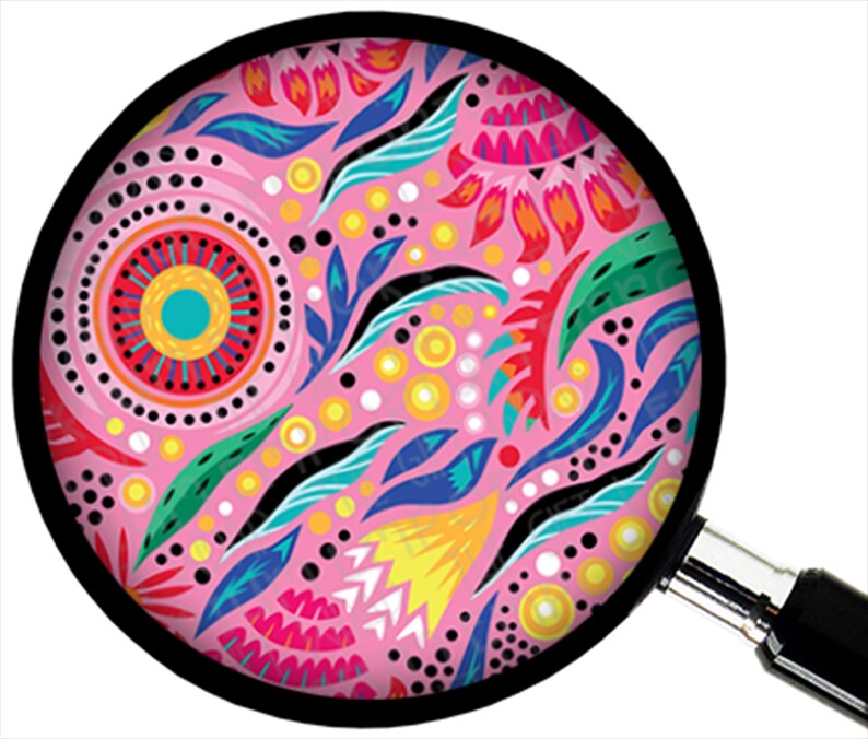 Puede incluir: Un dise&ntilde;o circular rosa con un borde negro se ve a trav&eacute;s de una lupa. El dise&ntilde;o presenta patrones florales y abstractos coloridos en tonos de rosa, rojo, azul, verde, amarillo y negro. La lupa tiene un mango negro y un borde plateado.