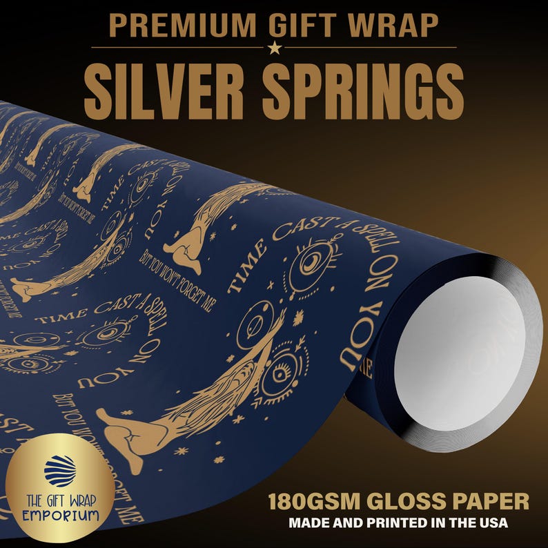 May include: A roll of dark blue gift wrap paper featuring a repeating gold-colored graphic pattern of stylized figures, eyes, and the text "TIME CAST A SPELL ON YOU BUT YOU WON'T FORGET ME". The paper is 180gsm gloss paper with a smooth finish.