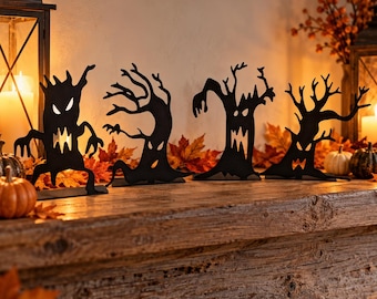 May include: Four black metal silhouettes of spooky, anthropomorphic trees with jagged branches and carved-out facial features. Each tree figure stands upright on a flat base, displaying distinct expressions with sharp eyes and mouths.