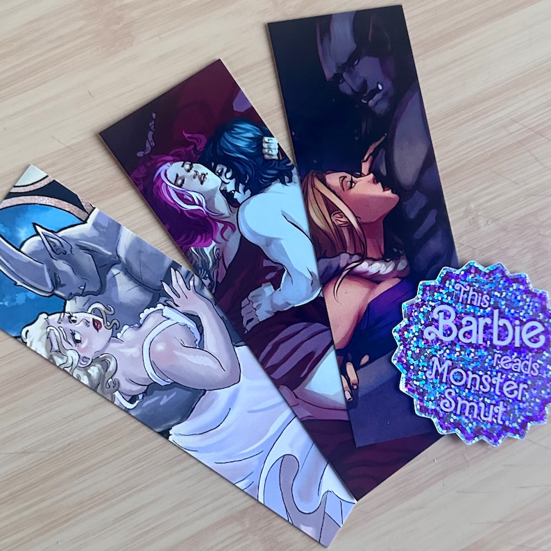 May include: Three bookmarks featuring illustrations of fantasy creatures and couples. The bookmarks are printed on thick cardstock and have a glossy finish. The first bookmark features a blue-skinned, horned creature with a woman in a white dress. The second bookmark features a woman with purple hair and a man with dark hair. The third bookmark features a woman with long blonde hair and a dark-skinned, horned creature.