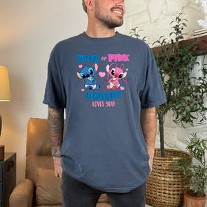Puede incluir: Una camiseta azul y azul marino con un gr&aacute;fico de Stitch y Angel sosteniendo biberones. El texto en la camiseta dice "Blue or Pink Robert Loves You!"