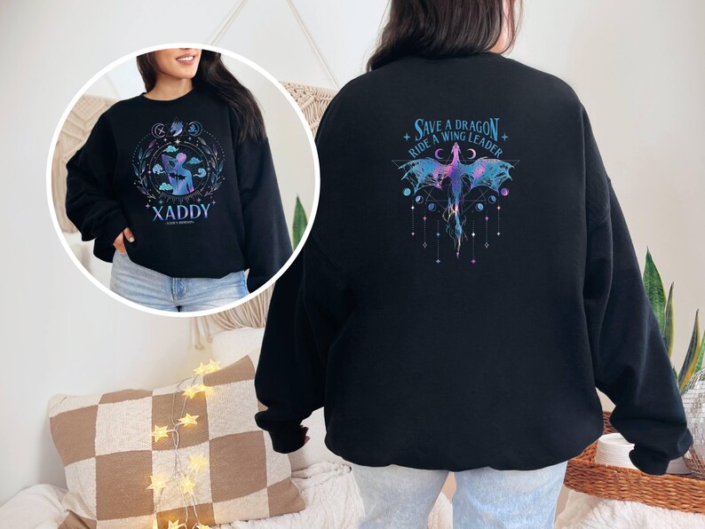 May include: Black sweatshirt with a purple and blue dragon graphic on the back. The text "Save a Dragon Ride a Wing Leader" is printed above the dragon. The front of the sweatshirt has a graphic of a person with the text "XADDY" printed below.