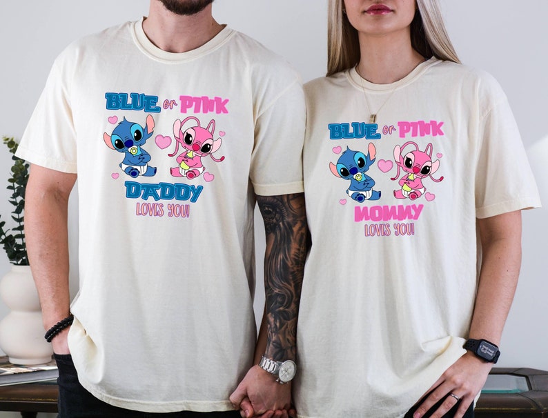 Puede incluir: Dos camisetas de color crema con un gr&aacute;fico de Stitch azul y rosa. El texto en las camisetas dice "Blue or Pink Daddy Loves You" y "Blue or Pink Mommy Loves You".