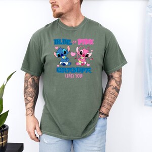 Puede incluir: Una camiseta verde con un gr&aacute;fico de personaje Stitch azul y rosa. El texto en la camiseta dice "Blue or Pink Grandpa Loves You".